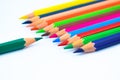 Line of different colored wood pencil crayons pointing at a blue color pencil