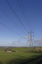 A line of Electricity Transmission Pylons stand amongst the Countryside and Farmland Royalty Free Stock Photo