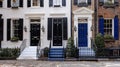 A line of elegant stately townhouses with classic black and white exteriors accented by deep navy blue doors and window