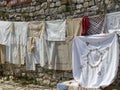 Line of embroidered tablecloths suspended along an ancient wall to Berat in Albania.