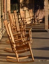 Line of empty wooden rocking chairs on porch in late afternoon symbol of Baby Boomers retirement years Royalty Free Stock Photo
