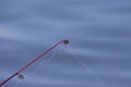 The line of fishing poles under dramatic sunset and beautiful sea Royalty Free Stock Photo