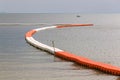 Line of floating orange and white buoys for marking safety zone. Royalty Free Stock Photo
