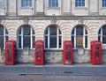 Line of four traditional british red phone boxes outside an old post office building in blackpool england Royalty Free Stock Photo