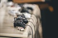 a row of video game controlleres plugged in and on the table Royalty Free Stock Photo
