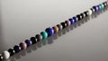 A line of glossy multi colored beads is arranged in a single Royalty Free Stock Photo