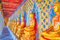 The line of golden Buddhas located in a coverd gallery of enclosure of Wat Arun Complex in Bangkok, Thailand Royalty Free Stock Photo