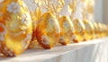 Line of Golden Easter Eggs with White Floral Designs on a Marble Surface golden eggs ornate Royalty Free Stock Photo