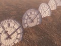 A line of half buried antique clocks