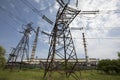 Line of high voltage equipment in sunny summer day in meadow. Blue sky. Grees grass Royalty Free Stock Photo