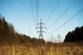 A line of high-voltage pillars through a plowed agricultural field Royalty Free Stock Photo