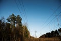 A line of high-voltage pillars through a plowed agricultural field Royalty Free Stock Photo