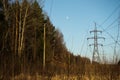 A line of high-voltage pillars through a plowed agricultural field Royalty Free Stock Photo