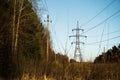 A line of high-voltage pillars through a plowed agricultural field Royalty Free Stock Photo