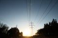 A line of high-voltage pillars through a plowed agricultural field Royalty Free Stock Photo