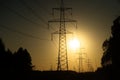 A line of high-voltage pillars through a plowed agricultural field Royalty Free Stock Photo