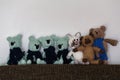 Line of homemade knitted toys on a sofa