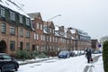 Line of houses with a backyard and a lot of snow on the roof and cars and roadthe background