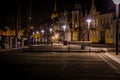 Line of houses during night lit by street light before the winter water front and harbor with ships