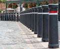 Line of large black bollards with red and white reflective banding. Royalty Free Stock Photo