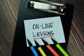 On-Line Lesson write on sticky note and isolated on Wooden Table. Educational Concept