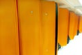 Line of many orange luggage bags and suitcases on the shelf conveyor