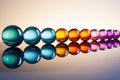 a line of marbles in gradient color order on a reflective surface Royalty Free Stock Photo