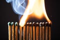 Line of matches without distance where they are lit one by one spreading the fire. COVID-19 spreads the same if there is not Royalty Free Stock Photo