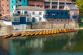 Line of moored rowing boats on the banks of River Wear near a boat club in Durham, United Kingdom on a beautiful spring afternoon