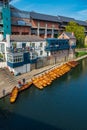 Line of moored rowing boats on the banks of River Wear near a boat club in Durham, United Kingdom on a beautiful spring afternoon