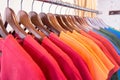 Line of multi colored clothes on wooden hangers in store. Sale Royalty Free Stock Photo