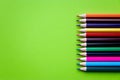 Line multicolored wooden pencils isolated on green background. Colored wooden crayons. Concept of art Royalty Free Stock Photo