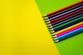 Line multicolored wooden pencils isolated on yellow-green. Colored wooden crayons Royalty Free Stock Photo