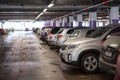 Line of a multistorey parking ramp full of parked cars, red light above each place