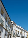 Line of old fashioned vintage facades of white colour against clear sky in Evora Portugal vertical backdrop
