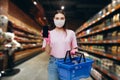 One young Caucasian woman buyer wearing face protective mask during the shopping. Healthy lifestyle concept