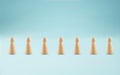 Line of people concept. Group of wooden figures lined up in row. Many wooden peg people in a row.