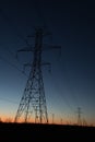 Line of power line towers around sunrise Royalty Free Stock Photo