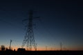 Line of power line towers around sunrise Royalty Free Stock Photo