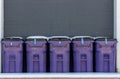The line of purple plastic trash cans Royalty Free Stock Photo