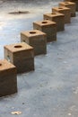 Line of several heavy stone cubes used in water fountain not yet working in warmer weather Royalty Free Stock Photo