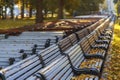 Line of shifted park benches, autumn sunny dayending of season, falling leaves, autumn mood, sadness