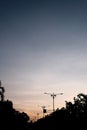 A line of silhouette of road lamps under the sunset