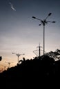 A line of silhouette of road lamps under the sunset