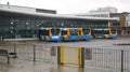 Line of single decker buses waiting in a bus station.