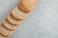 A line of slices of brown bread on a gray background Royalty Free Stock Photo