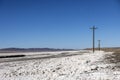 Line of telephone and power poles disappearing off into the distance in the desert salt flats Royalty Free Stock Photo