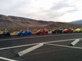 Line of two-seat scooter cars in parking lot with mountain landscape