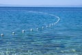 Line of white safety buoys in blue sea. Horizontal view. Copy space Royalty Free Stock Photo