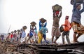 A line of Workers carrying the heavy loads of coal in baskets